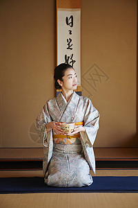 二十几岁榻榻米日式房间享受茶道的妇女图片