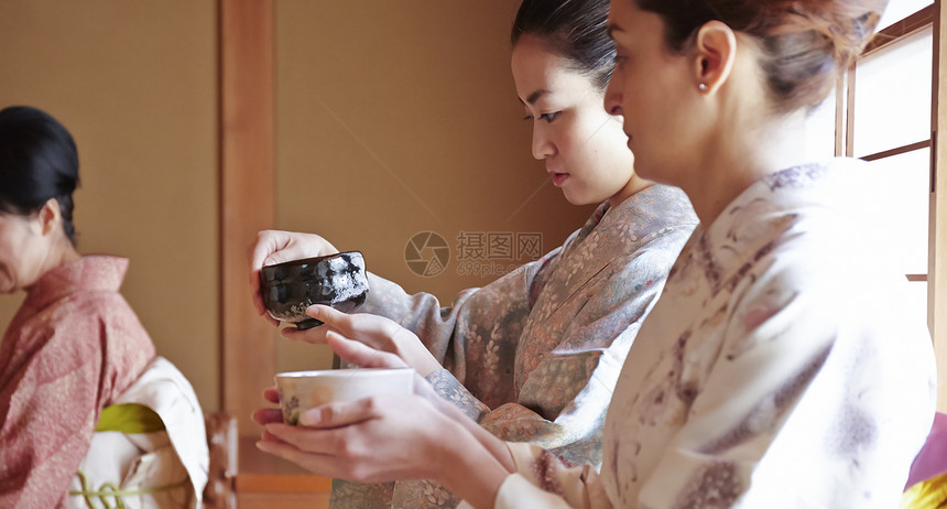 捧着绿茶容器体验茶道的外国游客图片