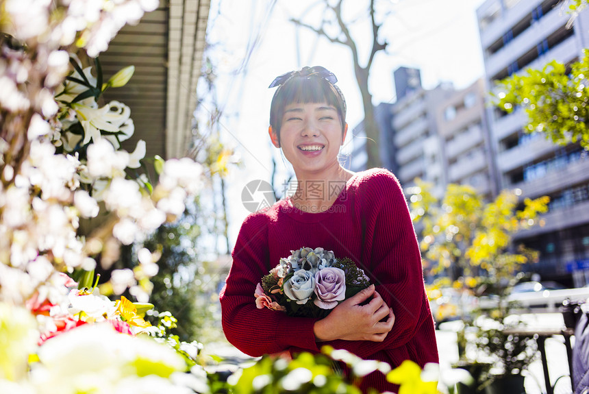  微笑抱着花束的女性图片