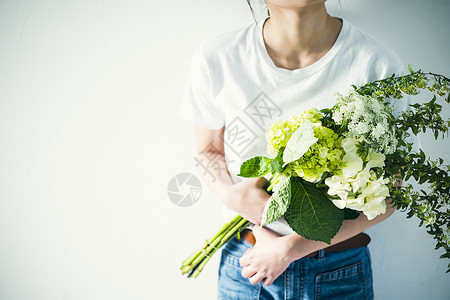 女人手捧花束特写图片