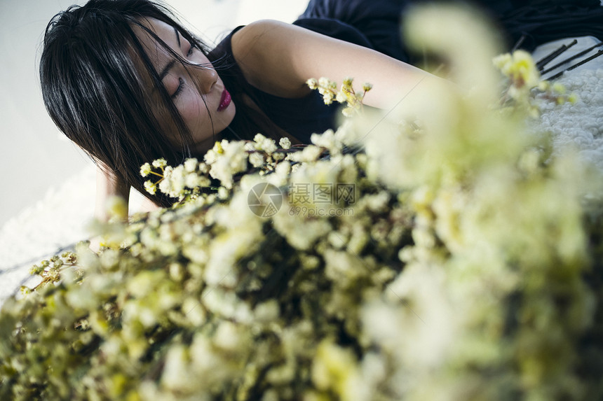 躺在花束旁的女子图片