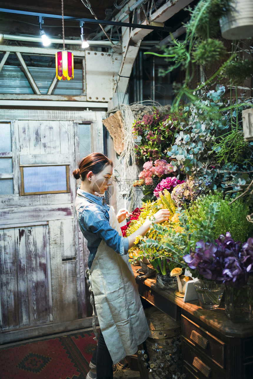 亚洲人欣赏微笑工作在花店的妇女图片