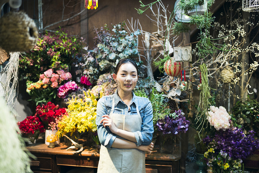 漂亮快乐高兴工作在花店的妇女图片