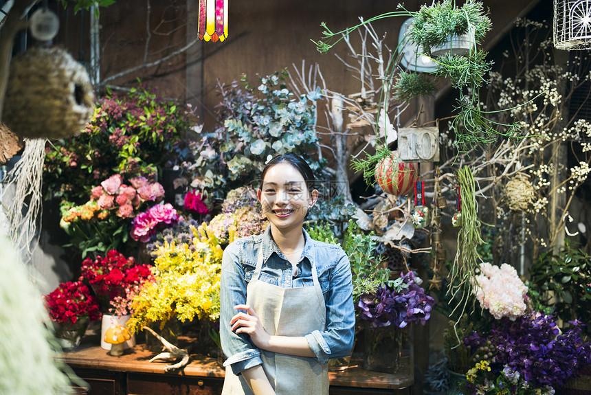 年轻店内室内盆栽工作在花店的妇女图片