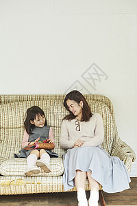 孩子跟妈妈一起坐在沙发上玩耍图片