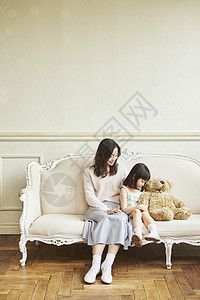 母亲和女儿抱着娃娃坐一起图片