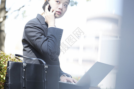 白天商务女性拿着电脑打电话图片
