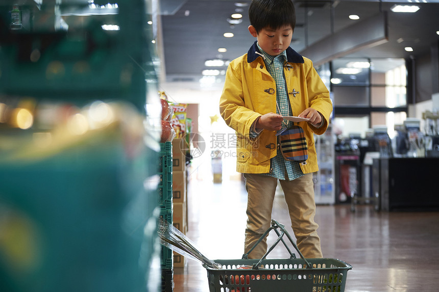 小男孩独自购物查看清单图片