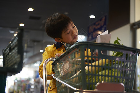 看着购物清单购物的小男孩图片