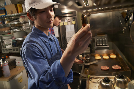 汉堡店厨房厨师在调味料理图片