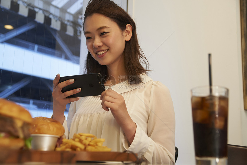 一个女人在汉堡店用餐拍照图片