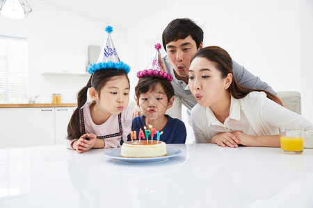 庆祝生日吹蛋糕的一家人图片