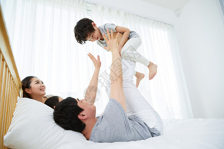 床上玩耍的幸福一家人图片