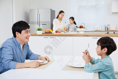 父亲和儿子坐在餐桌上图片