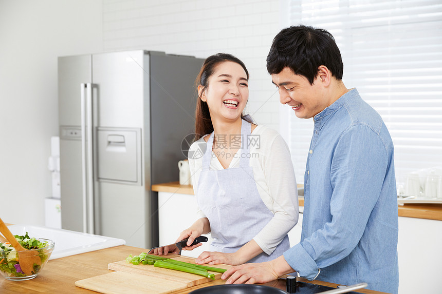 年轻夫妻在厨房一起做饭图片