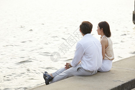 坐在河边游玩的情侣图片