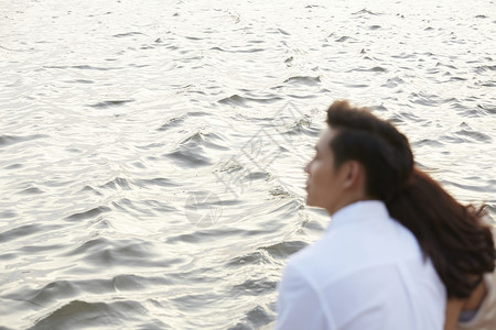 坐在海边的年轻夫妇背景图片