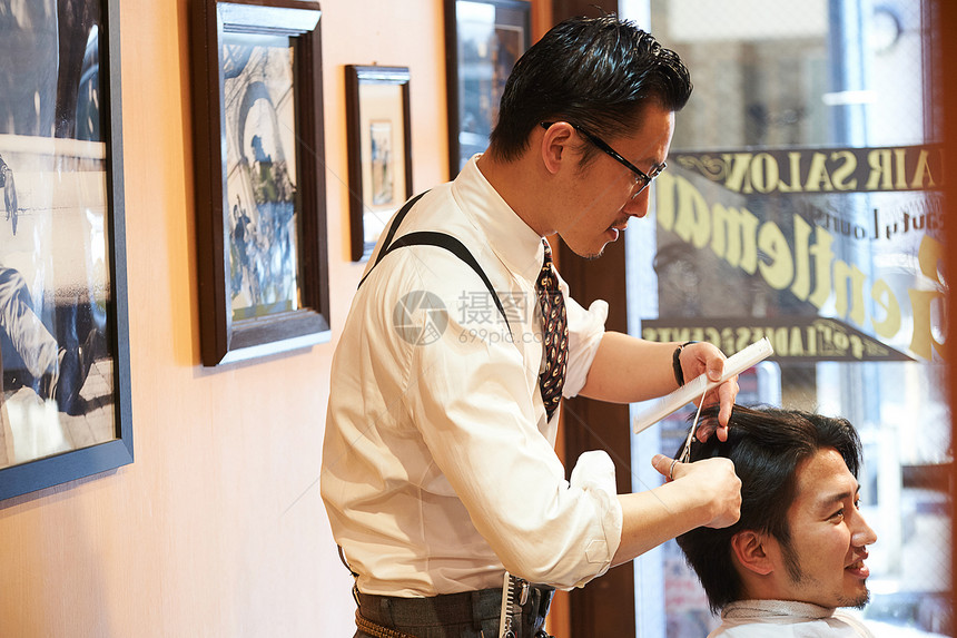 正在给客人剪头发的理发师图片