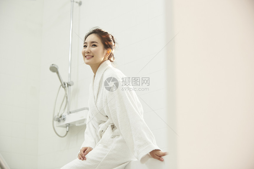 浴室里穿着浴袍的年轻女性图片