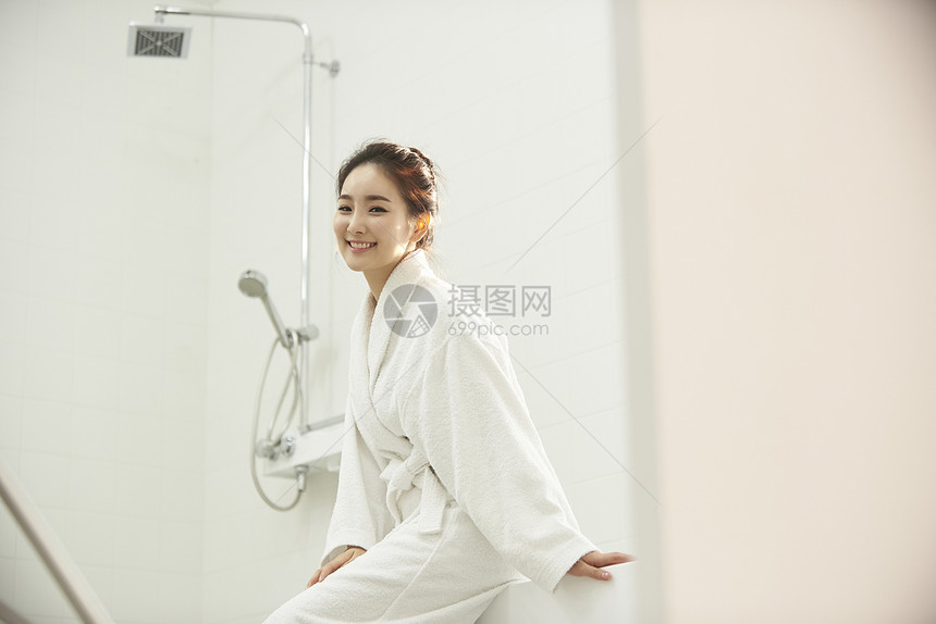 浴室里穿着浴袍的年轻女性图片