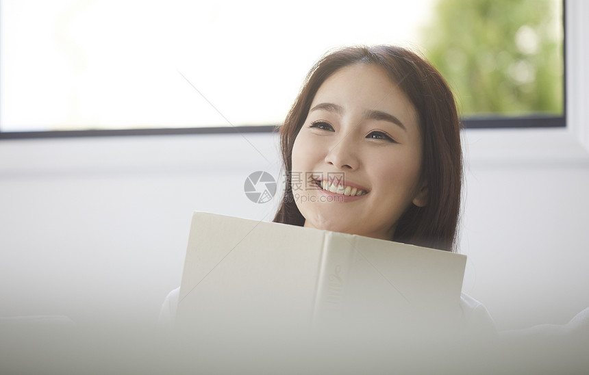 拿着书微笑的女青年图片