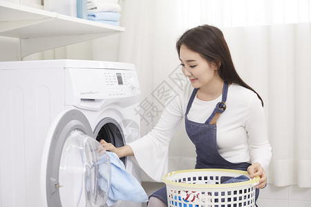 将换洗衣物放入洗衣机的女性图片