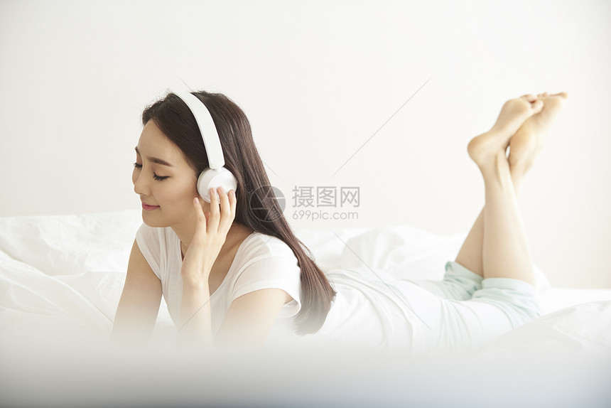 戴着耳机听音乐放松的年轻女性图片