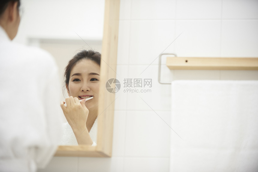 穿着浴袍洗漱的年轻女性图片