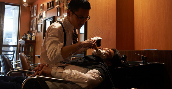 时髦胡须室内剃须理发师刮男客人图片