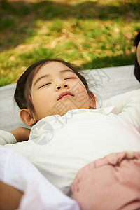 户外躺在野餐垫上睡觉的小女孩图片