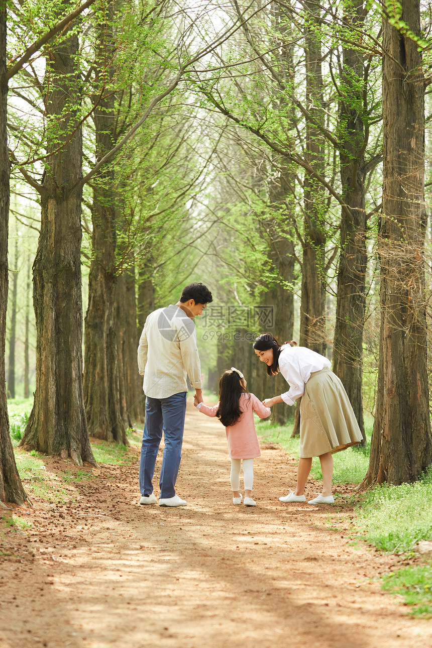 公园里散步游玩的家庭背影图片