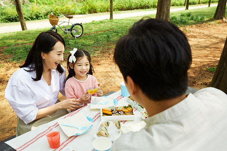 公园里野餐开心的三口之家图片