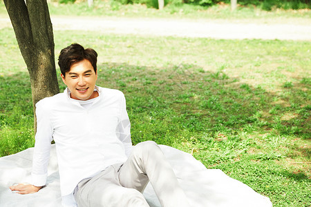 户外野餐垫上休息的成年男性图片