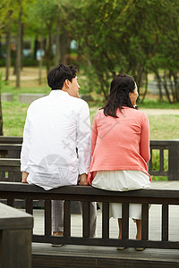 坐在栏杆上的夫妇背影背景图片