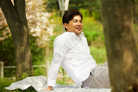 坐在草坪上休息的男性图片