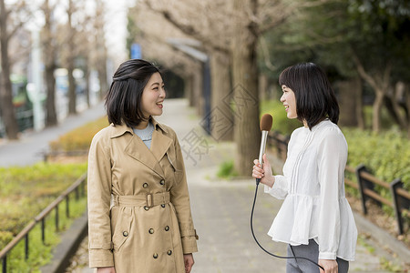 拿着麦克风采访路人的女记者图片