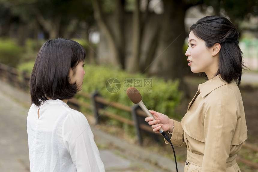 拿着话筒街头采访的女播音员图片