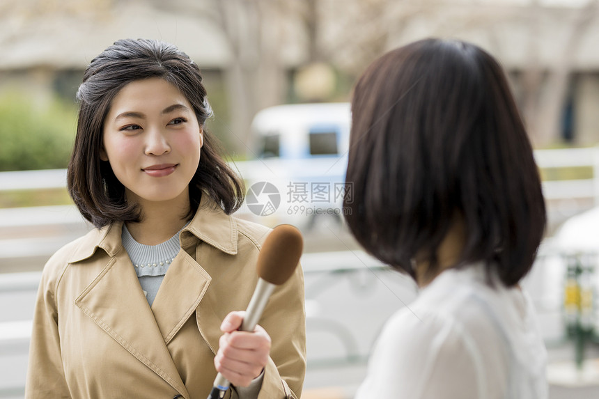 拿着话筒街头采访的女播音员图片