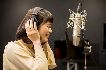 天津广播电视台录音棚带着耳机录音的年轻女性背景