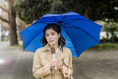 室外下雨天报道的年轻记者图片