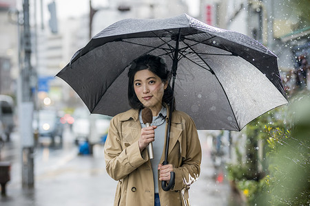 户外街头播报新闻的女记者背景图片