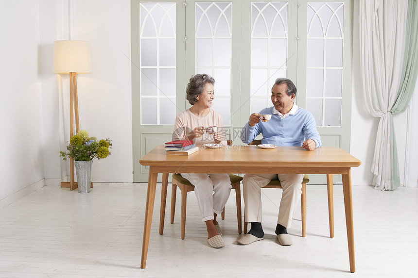 餐桌上喝茶的老年夫妇图片