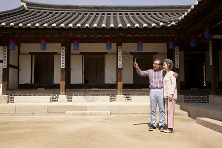 参观传统村落房屋自拍的老年夫妇图片