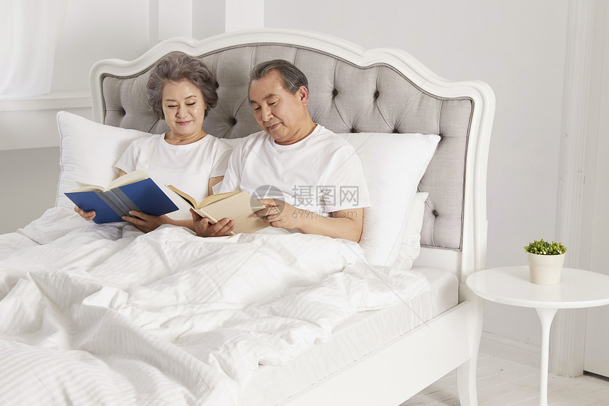 卧室里看书休息的老年夫妇图片