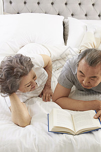 床上看书的老年夫妇图片