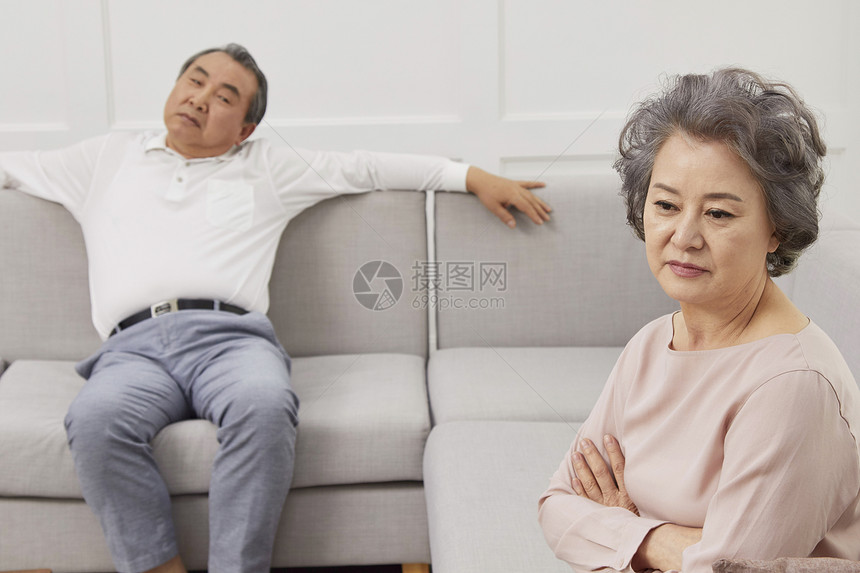 客厅沙发上闹变扭的老年夫妇图片