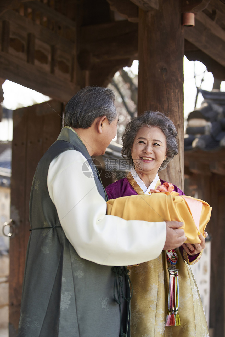 穿着传统服装拿着礼物的夫妇图片