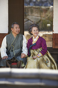 民俗村坐在屋外穿着传统服装的夫妻图片