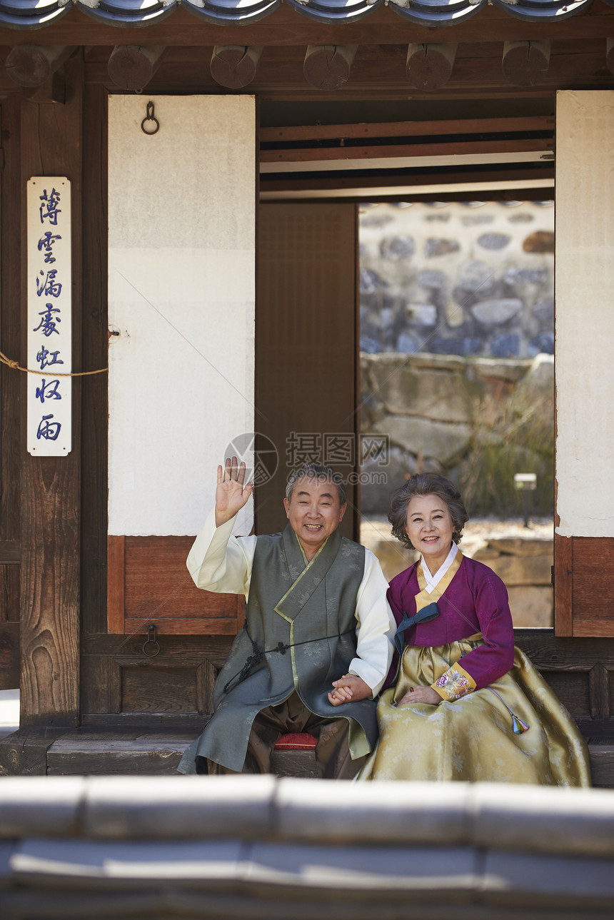 坐在屋外穿着传统服装开心的夫妻图片