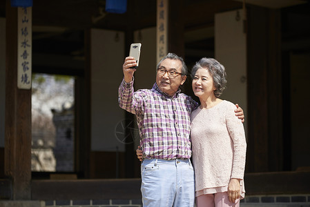 民俗屋参观拿着手机自拍的夫妇图片